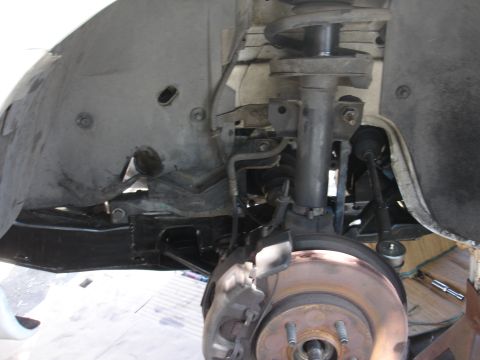 1992 Ford Taurus - Close-up view of the front suspension system, showing the brake assembly and shock absorber.