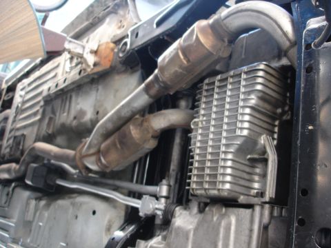 1992 Ford Taurus - The underside of a vehicle is shown, focusing on the exhaust system and the ribbed oil pan.