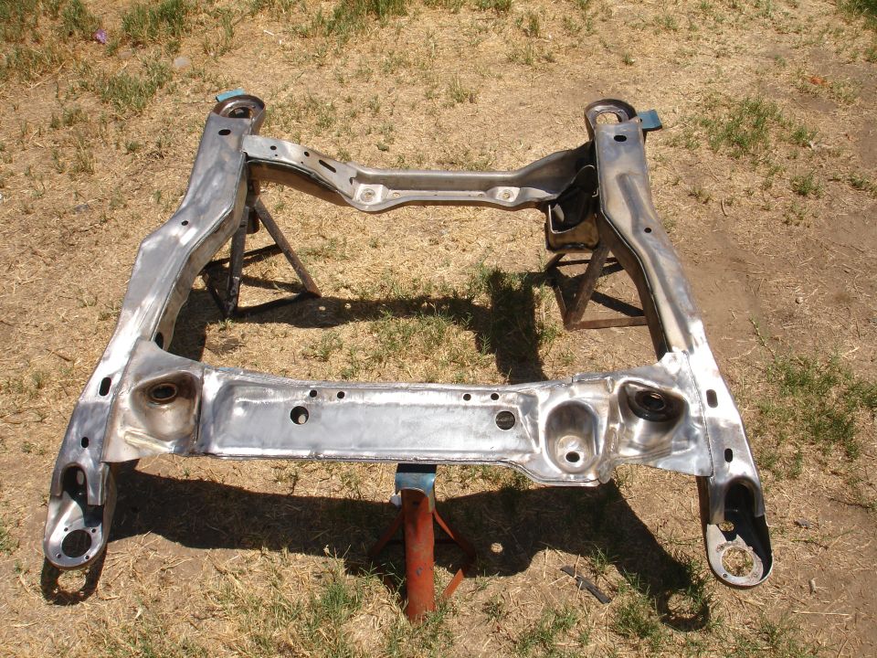 Metal subframe assembly resting on two jack stands outdoors