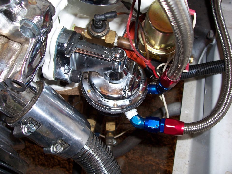 Close-up of a chrome fuel pump with braided fuel lines connected