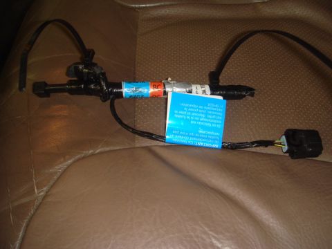 1996 Ford Bronco - A close-up of a vehicle's seat belt sensor wire harness, showing its connection and warning labels.