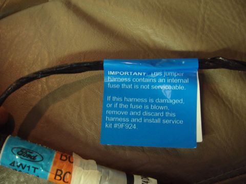 1996 Ford Bronco - Ford wiring harness with a blue label detailing its internal fuse and replacement procedure.