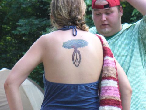 1991 Ford Probe - A woman displays a tattoo on her back while a man stands behind her, partially visible.