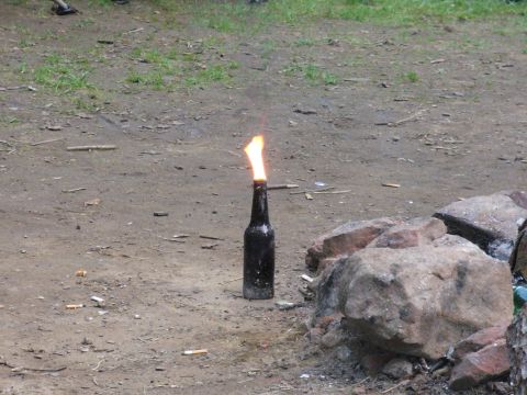 1991 Ford Probe - A makeshift incendiary device sits on the ground, surrounded by rocks and cigarette butts.