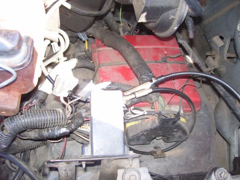 1986 Ford Bronco - Engine bay wiring and components, including a red battery box, are visible in this close-up shot.