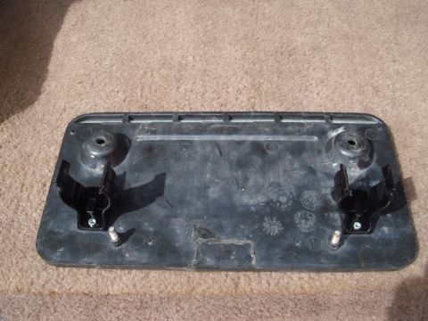 1996 Ford Bronco - This is a close-up view of a black plastic mounting bracket with two clips and screw holes.