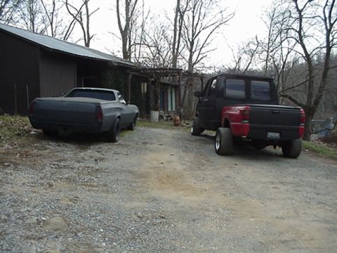 1972 Ford Ranchero - Three vehicles are parked in a gravel driveway in front of a building.