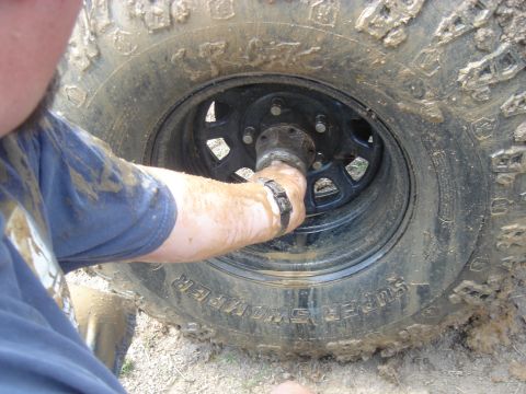1979 Ford F-250 - A person's hand is shown working on the hub of a muddy tire, suggesting off-road activity.