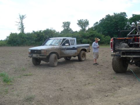 1979 Ford F-250 - A muddy pickup truck is parked in a field, with another vehicle visible to the right.