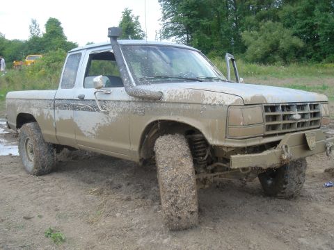1979 Ford F-250 - This mud-covered pickup truck, likely an early 1980s Ford Ranger, is equipped with a snorkel for off-road use.
