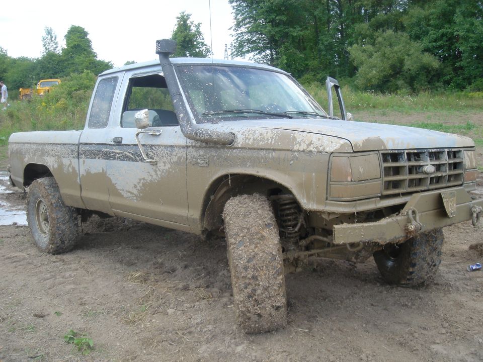 Mud-covered pickup truck with snorkel, 3q-front view. Appears to be a Ford Ranger from the early 1980s