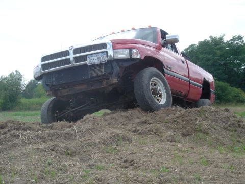 1979 Ford F-250 - Red pickup truck is stuck in a dirt mound, with its front end elevated.