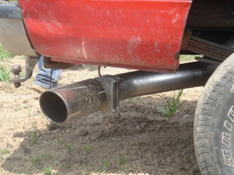1979 Ford F-250 - Custom exhaust pipe installation on a red truck, showing rear suspension components.