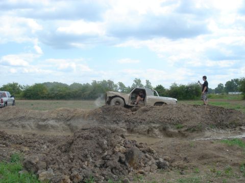 1979 Ford F-250 - A truck navigates a challenging muddy terrain, with a second vehicle in the background.