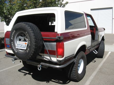 1991 Ford Bronco - This Ford Bronco features a two-tone paint job and a custom rear bumper with integrated tow hooks.