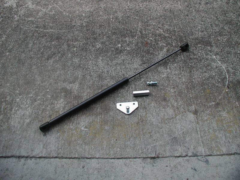 Black gas lift strut with ball stud bracket and spacer on concrete