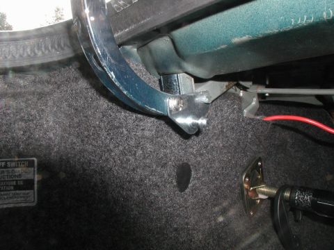 1990 Ford Thunderbird - Close-up view of a trunk strut mechanism, showing mechanical components and a label with text.