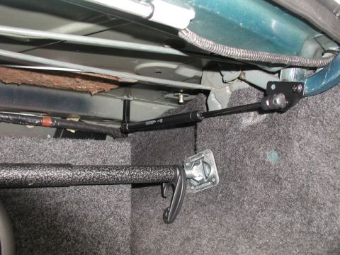 1990 Ford Thunderbird - Close-up view of a trunk strut and latch mechanism, showing the part and its mounting hardware.