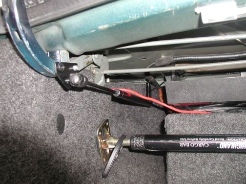 1990 Ford Thunderbird - Trunk strut and cargo bar assembly with visible red wiring.