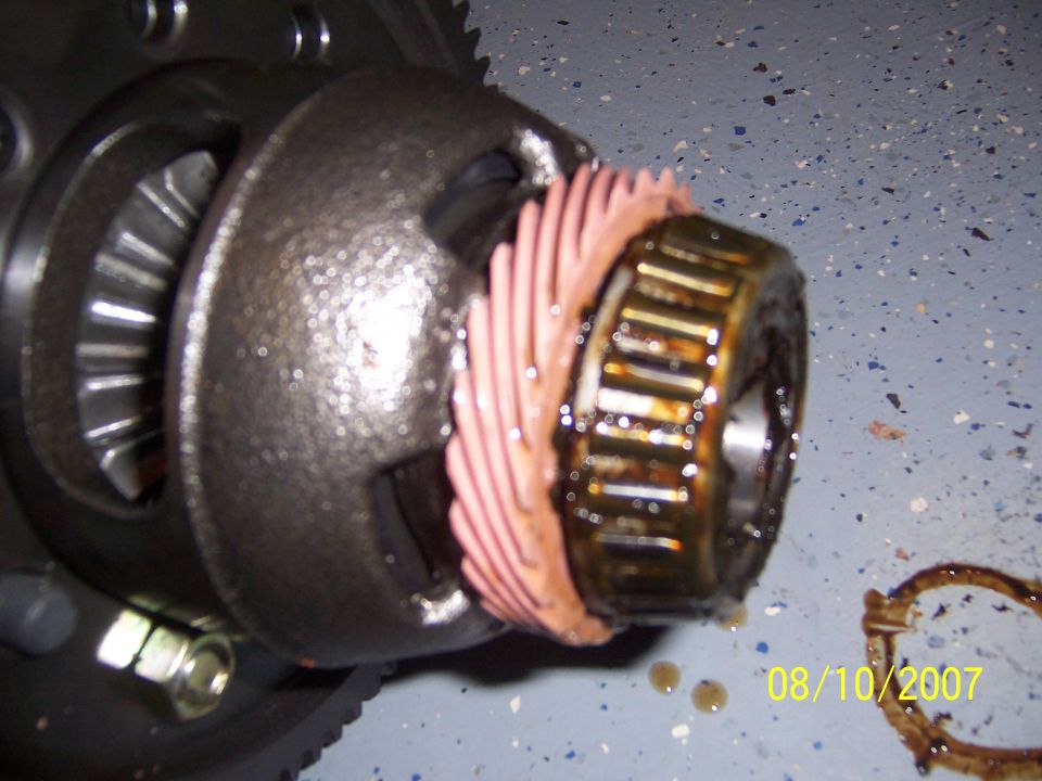 Differential assembly with helical gear and oily roller bearing on a blue speckled floor, dated 08/10/2007
