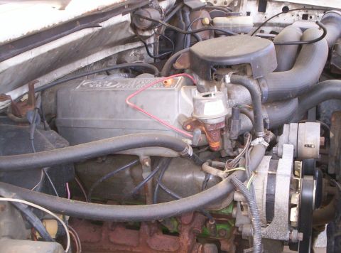 1995 Ford Bronco - Engine bay of a Ford truck viewed from the driver's side, showing the fuel-injected V8's gray plastic upper intake with the Ford oval, the…