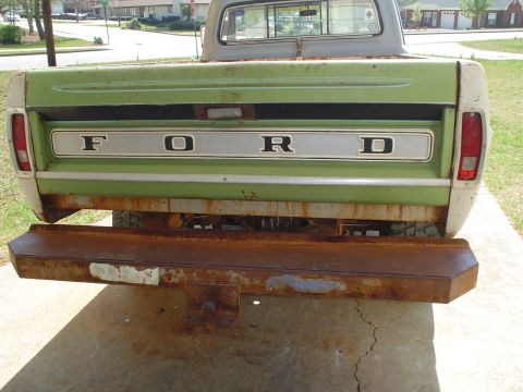 1967 Ford F-250 - The rear of a 1967 Ford F-250 pickup truck, its iconic tailgate and a heavily rusted bumper.