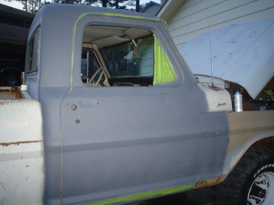 Gray 1967 Ford F-250 truck cab, primer applied, driver's side door and fender visible, hood up