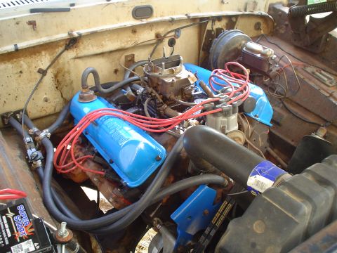 1967 Ford F-250 - Engine bay view showing V8 engine components including carburetor, distributor, and valve covers.