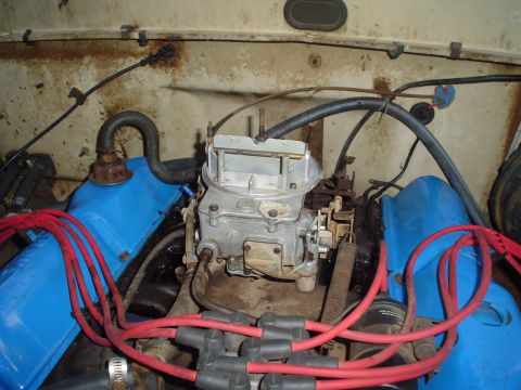 1967 Ford F-250 - The engine bay shows a carburetor and blue valve covers, with red spark plug wires.