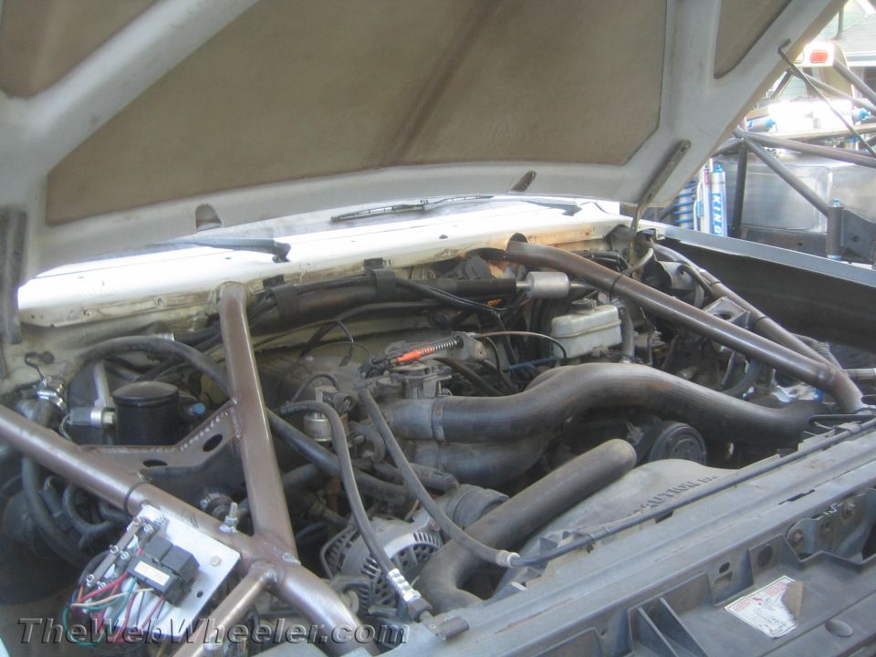 Engine bay with tubular cage tubes, V8 engine and exhaust manifolds