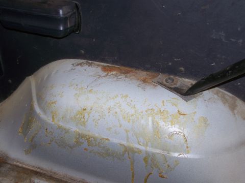 1986 Ford Bronco - The interior floor pan of a 1986 Ford Bronco exhibits signs of rust and staining.