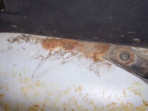 1986 Ford Bronco - Close-up of a rusted metal panel, likely from a vehicle's interior floor, showing signs of wear and corrosion.