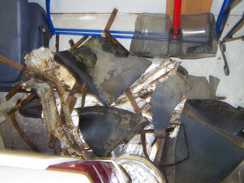 1986 Ford Bronco - Disassembled vehicle interior parts are piled up, showing signs of wear and damage.