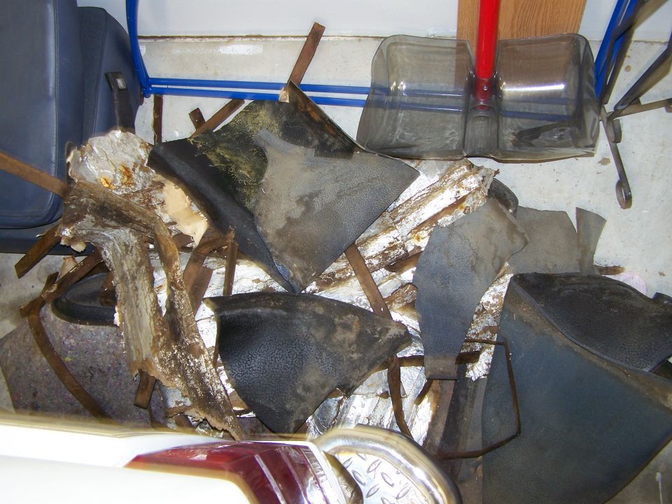 Pile of torn and discolored vehicle floor mats and insulation