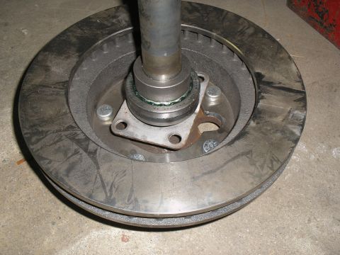 1990 Ford Bronco - Close-up view of a vehicle's brake rotor and hub assembly, showing mechanical components and grease.