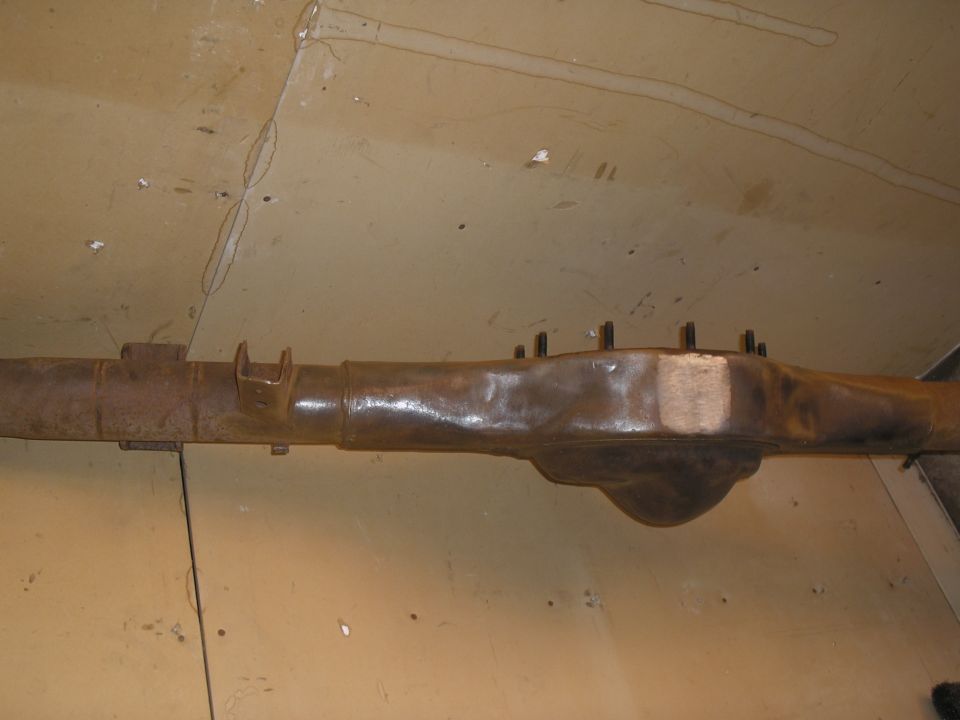 Rusty rear axle housing with U-bolt perches visible