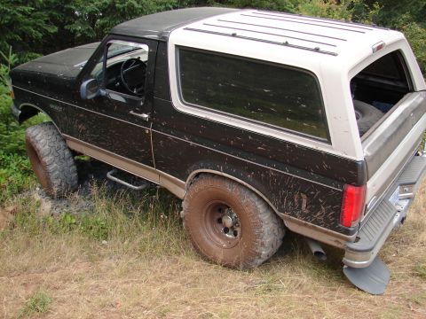 1996 Ford Bronco - This 1996 Ford Bronco is shown off-road, with mud splattered on its body and tires.