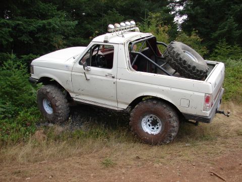 1996 Ford Bronco - Modified 1996 Ford Bronco equipped for off-road use, large tires and a spare tire mounted in the cargo area.