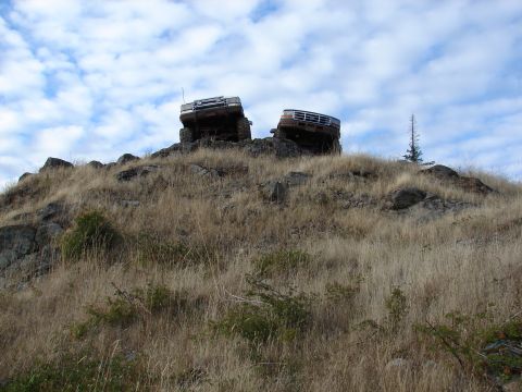 1996 Ford Bronco - Two SUVs navigate a challenging rocky terrain, climbing a steep hill.