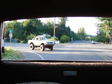 1996 Ford Bronco - Modified pickup truck seen from inside another vehicle on a sunny day.