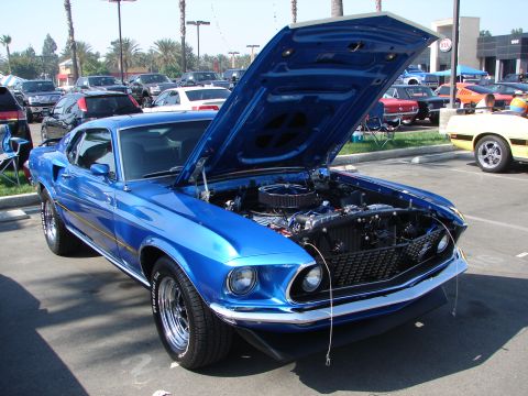 1992 Ford Taurus - A bright blue 1969 Ford Mustang is displayed with its hood open, revealing the engine bay.