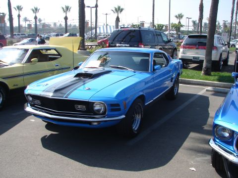 1992 Ford Taurus - A blue 1970 Ford Mustang Mach 1 is parked at an outdoor car show.