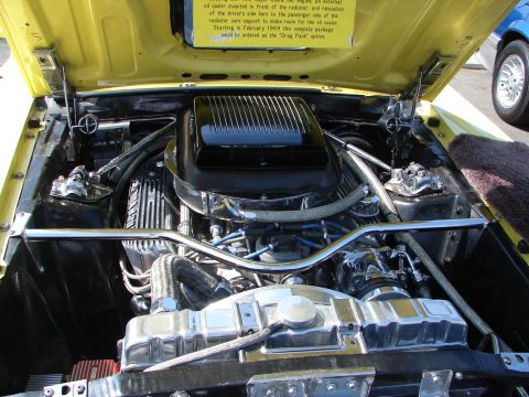 1992 Ford Taurus - The engine bay of a yellow car is shown, chrome components and a black air cleaner assembly.