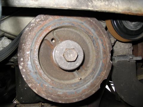 1993 Ford Taurus - Crankshaft pulley showing signs of wear and rust, with a central hex bolt visible.
