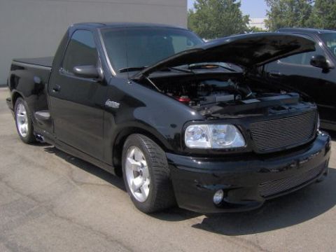 1991 Ford Taurus - This black 1999 Ford F-150 SVT Lightning pickup truck is shown from a 3q front view with its hood open.