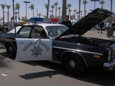 1991 Ford Taurus - A vintage California Highway Patrol car is displayed with its hood and door open.