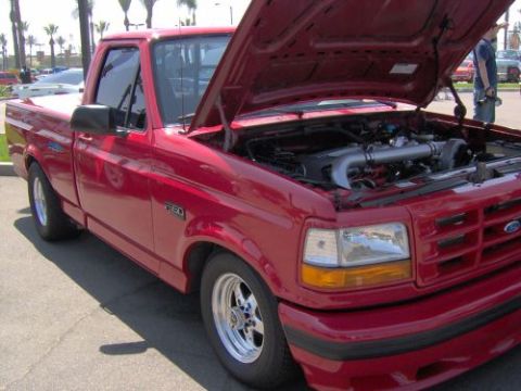 1991 Ford Taurus - Red 1992 Ford F-150 pickup truck with hood open, displaying engine modifications and aftermarket wheels.