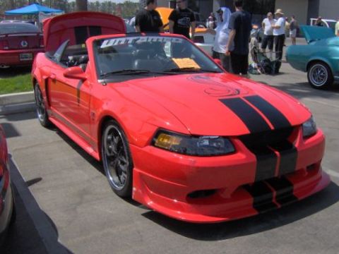 1991 Ford Taurus - Red convertible Mustang with black racing stripes and a "Fahrenheit" banner on the windshield.