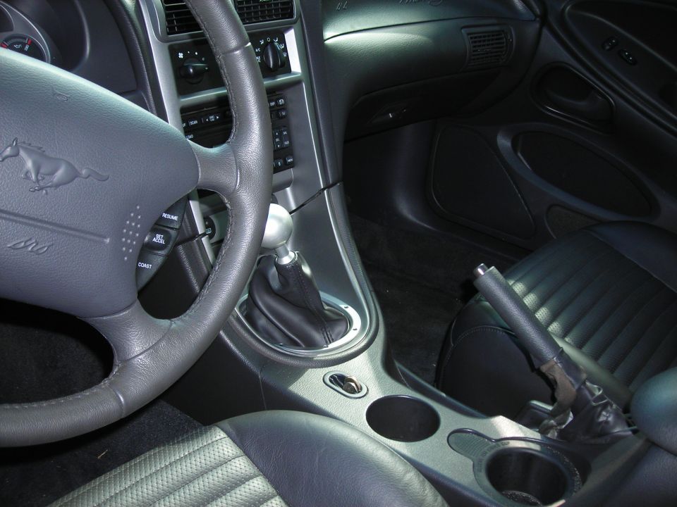 2003 Ford Mustang interior showing steering wheel with horse emblem, shifter, and center console