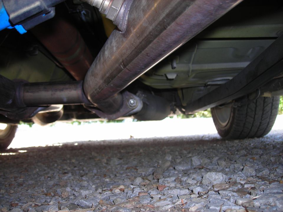 Underside view of a vehicle's exhaust system and rear tire